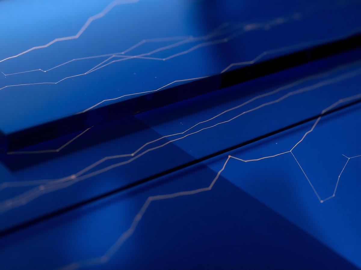 Abstract navy glass surfaces etched with fine gold performance lines